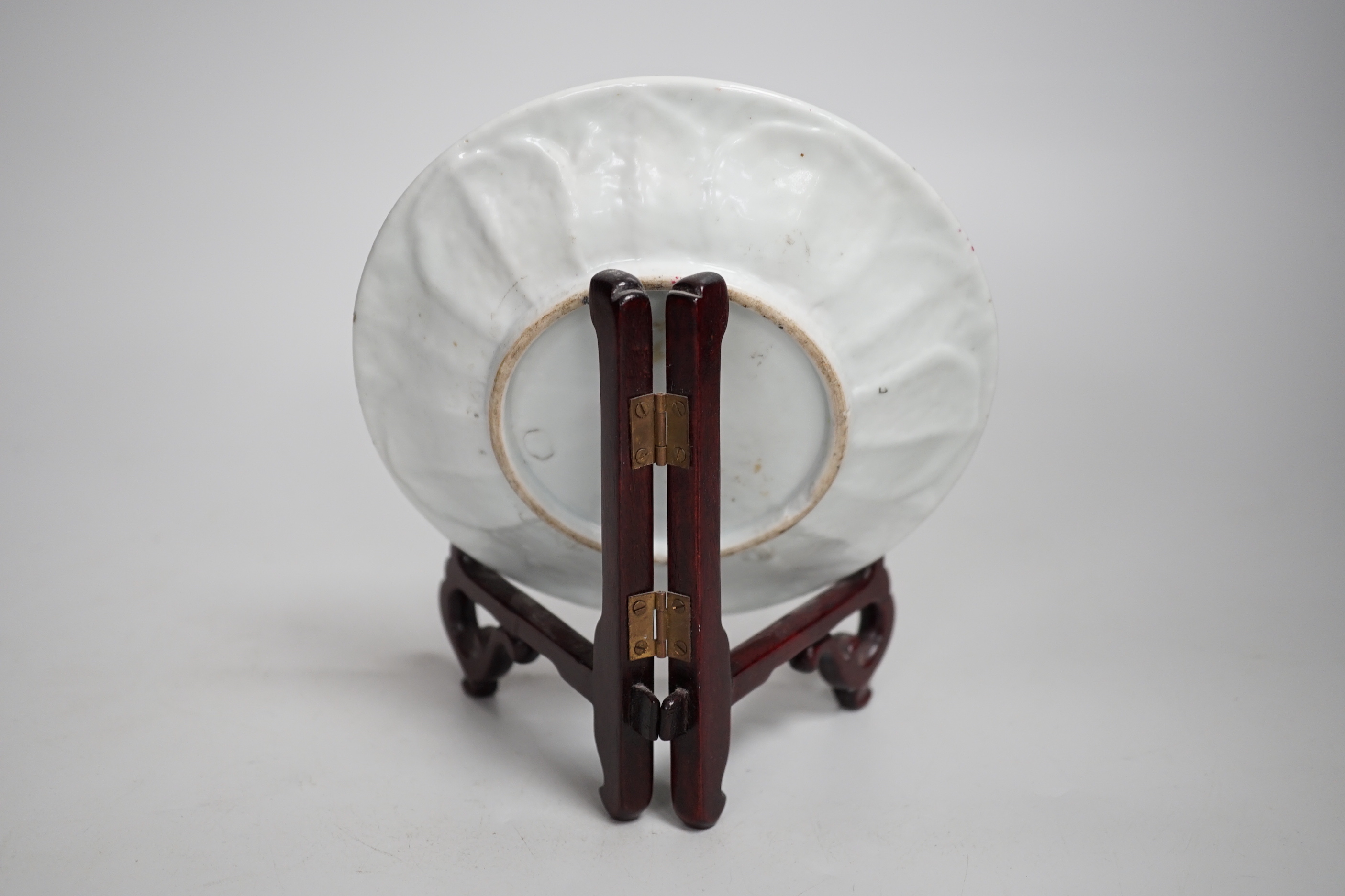 A Chinese famille rose cup stand, early Qianlong period, decorated in relief with a flowerhead, 15cm in diameter